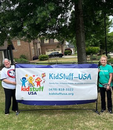 Jessica Armstrong and Allison Reeves with KidStuff-USA banner