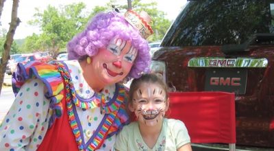 Clown with child at KidStuff event