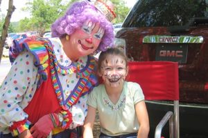 Clown and child with face paint at a KidStuff event